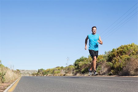 rodovia 40 - Athletic man jogging on the open road on a sunny day Foto de stock - Royalty-Free Super Valor e Assinatura, Número: 400-07725254