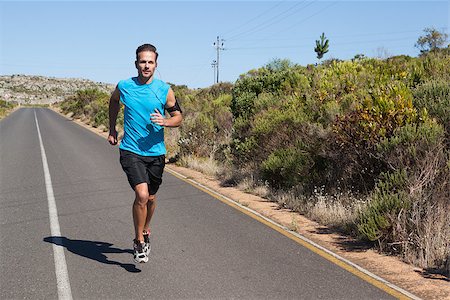 rodovia 40 - Athletic man jogging on open road on a sunny day Foto de stock - Royalty-Free Super Valor e Assinatura, Número: 400-07725266