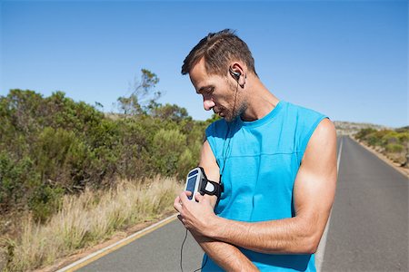 simsearch:400-07725266,k - Athletic man adjusting his music player on a run on a sunny day Photographie de stock - Aubaine LD & Abonnement, Code: 400-07725269