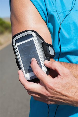 simsearch:400-08017390,k - Athletic man adjusting his music player on a run on a sunny day Photographie de stock - Aubaine LD & Abonnement, Code: 400-07725270