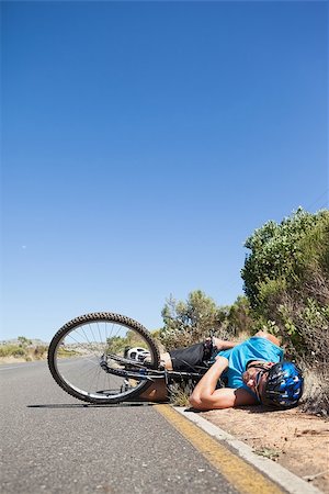 rodovia 40 - Cyclist lying on the road after an accident on a sunny day Foto de stock - Royalty-Free Super Valor e Assinatura, Número: 400-07725285