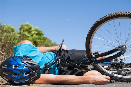 rodovia 40 - Cyclist lying on the road after an accident on a sunny day Foto de stock - Royalty-Free Super Valor e Assinatura, Número: 400-07725286