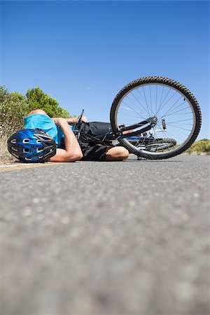 rodovia 40 - Cyclist lying on the road after an accident on a sunny day Foto de stock - Royalty-Free Super Valor e Assinatura, Número: 400-07725287