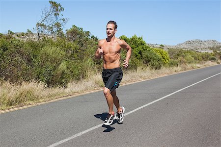 simsearch:400-07725266,k - Shirtless man jogging on open road  on a sunny day Photographie de stock - Aubaine LD & Abonnement, Code: 400-07725280