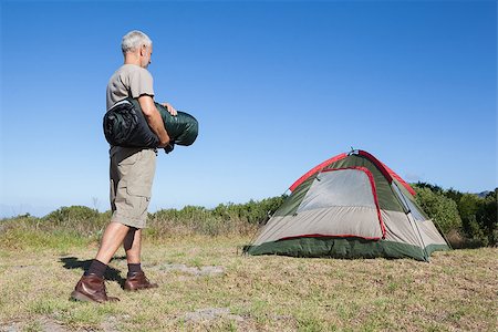 sleep in camper - Happy camper walking towards his tent holding sleeping bag on a sunny day Stock Photo - Budget Royalty-Free & Subscription, Code: 400-07725376
