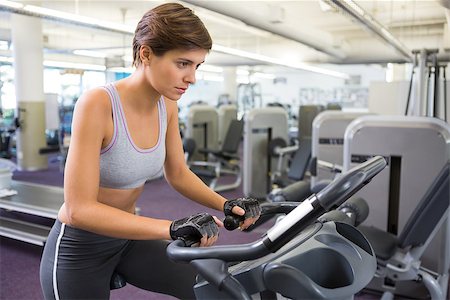 simsearch:400-07725687,k - Fit brunette working out on the exercise bike at the gym Photographie de stock - Aubaine LD & Abonnement, Code: 400-07725676