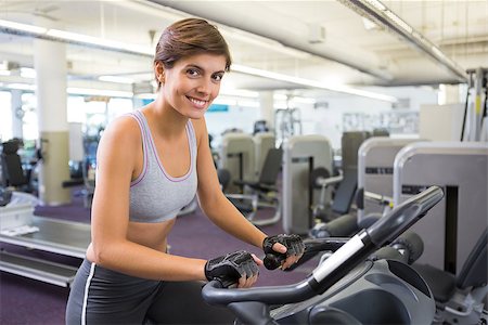 simsearch:400-07725687,k - Fit brunette working out on the exercise bike at the gym Photographie de stock - Aubaine LD & Abonnement, Code: 400-07725677