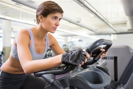 simsearch:400-07725687,k - Fit brunette working out on the exercise bike at the gym Photographie de stock - Aubaine LD & Abonnement, Code: 400-07725678