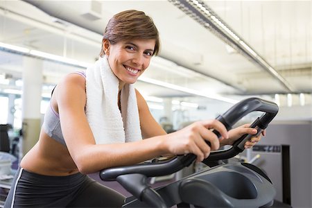 simsearch:400-07725772,k - Fit smiling brunette working out on the exercise bike at the gym Photographie de stock - Aubaine LD & Abonnement, Code: 400-07725681