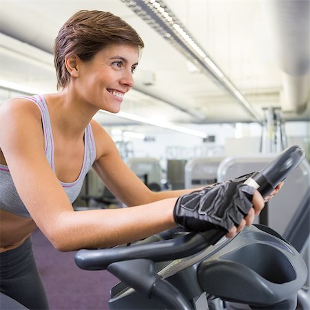 simsearch:400-07725687,k - Fit smiling woman working out on the exercise bike at the gym Photographie de stock - Aubaine LD & Abonnement, Code: 400-07725690