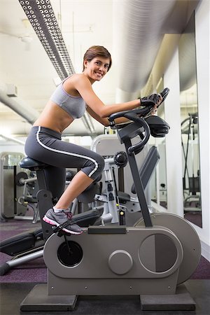 simsearch:400-07725687,k - Fit smiling woman working out on the exercise bike at the gym Photographie de stock - Aubaine LD & Abonnement, Code: 400-07725692