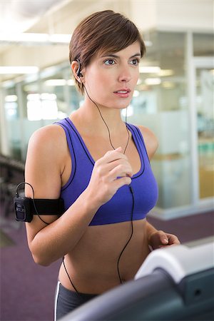 simsearch:400-07725931,k - Fit brunette running on the treadmill listening to music at the gym Photographie de stock - Aubaine LD & Abonnement, Code: 400-07725759