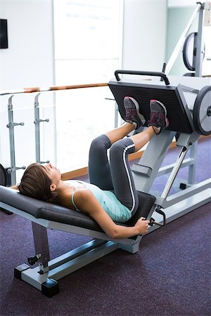 simsearch:400-07725772,k - Fit brunette using weights machine for legs at the gym Photographie de stock - Aubaine LD & Abonnement, Code: 400-07725778