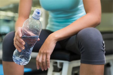 simsearch:400-07725931,k - Fit woman sitting on bench holding water bottle at the gym Photographie de stock - Aubaine LD & Abonnement, Code: 400-07725810