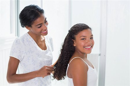 Pretty mother brushing her daughters hair at home in bathroom Stock Photo - Budget Royalty-Free & Subscription, Code: 400-07725962