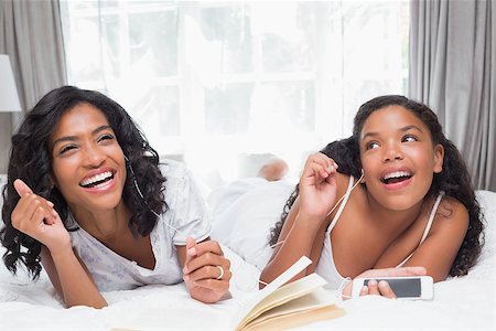 simsearch:614-06442610,k - Mother and daughter reading book and listening to music together on bed at home in bedroom Stockbilder - Microstock & Abonnement, Bildnummer: 400-07725997