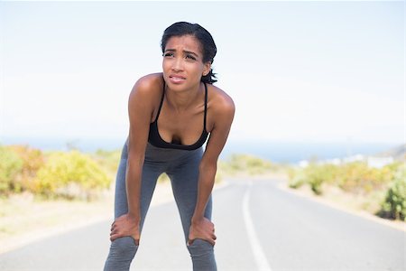 simsearch:400-07725266,k - Fit woman taking a break on the open road on a sunny day in the countryside Photographie de stock - Aubaine LD & Abonnement, Code: 400-07726087