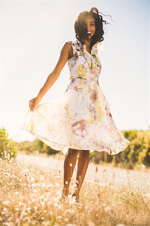 Happy pretty woman standing on the grass in floral dress on a sunny day in the countryside Stock Photo - Budget Royalty-Free & Subscription, Code: 400-07726121