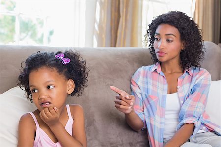 Pretty mother sitting on couch scolding petulant daughter at home in the living room Stock Photo - Budget Royalty-Free & Subscription, Code: 400-07726231