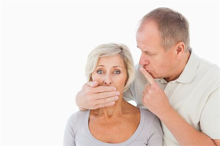 simsearch:400-07726420,k - Man silencing his fearful partner on white background Fotografie stock - Microstock e Abbonamento, Codice: 400-07726419