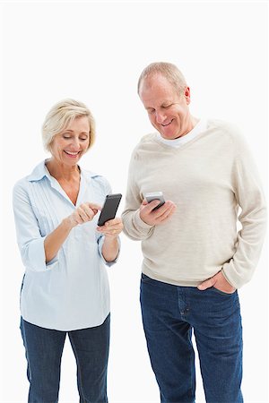 Happy mature couple using their smartphones on white background Stock Photo - Budget Royalty-Free & Subscription, Code: 400-07726534