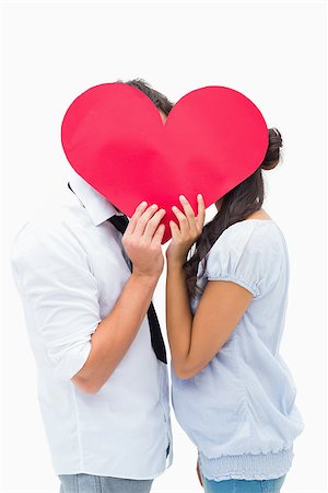 simsearch:400-07726699,k - Couple covering their kiss with a heart on white background Foto de stock - Super Valor sin royalties y Suscripción, Código: 400-07726703