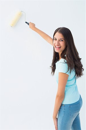 Happy young brunette painting with roller on white background Stock Photo - Budget Royalty-Free & Subscription, Code: 400-07726805