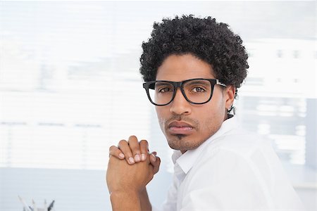 simsearch:400-07778671,k - Hipster businessman looking at camera in his office Fotografie stock - Microstock e Abbonamento, Codice: 400-07727428