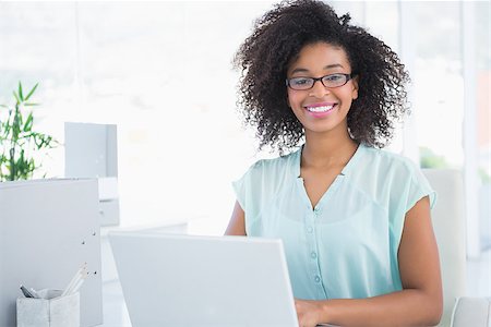 simsearch:400-07926810,k - Happy hipster businesswoman working on laptop in her office Fotografie stock - Microstock e Abbonamento, Codice: 400-07727660