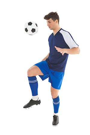 football man kicking white background - Football player in blue jersey kicking ball on white background Stock Photo - Budget Royalty-Free & Subscription, Code: 400-07727869