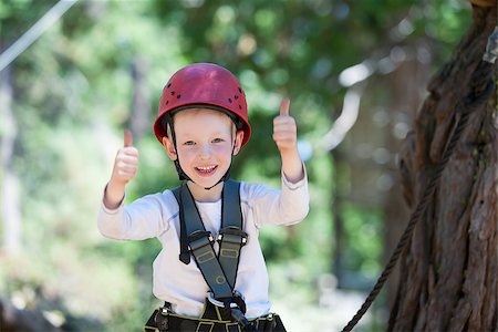 brave little boy having fun at adventure park and giving double thumbs-up Foto de stock - Super Valor sin royalties y Suscripción, Código: 400-07728759