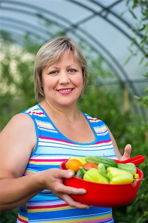 Portrait of a woman with vegetables in a bowl near greenhouses Stock Photo - Budget Royalty-Free & Subscription, Code: 400-07720497