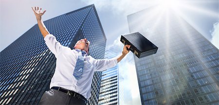 Businessman holding briefcase and cheering against low angle view of skyscrapers Stock Photo - Budget Royalty-Free & Subscription, Code: 400-07720668