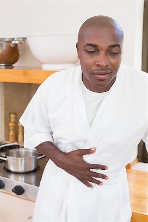 person with cramps - Sick man in bathrobe clutching stomach at home in the kitchen Stock Photo - Budget Royalty-Free & Subscription, Code: 400-07722129