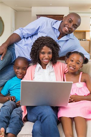 Happy family relaxing on the couch using laptop at home in the living room Stock Photo - Budget Royalty-Free & Subscription, Code: 400-07722172