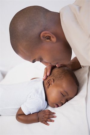 simsearch:614-03576718,k - Baby boy sleeping peacefully on couch with father kissing head at home in the living room Photographie de stock - Aubaine LD & Abonnement, Code: 400-07722293