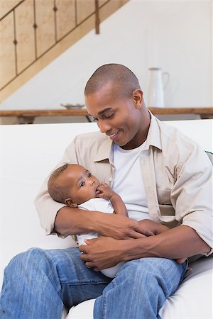 simsearch:614-03576718,k - Happy father spending time with baby on the couch at home in the living room Photographie de stock - Aubaine LD & Abonnement, Code: 400-07722497