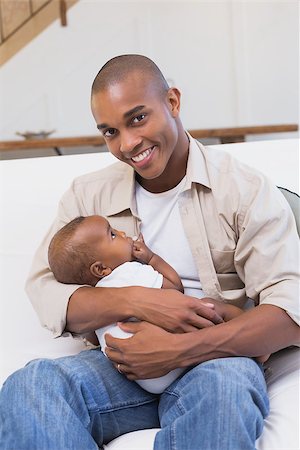 simsearch:614-03576718,k - Happy father spending time with baby on the couch at home in the living room Photographie de stock - Aubaine LD & Abonnement, Code: 400-07722498