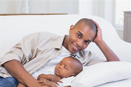 simsearch:614-03576718,k - Happy young father with baby son on couch at home in the living room Photographie de stock - Aubaine LD & Abonnement, Code: 400-07722524