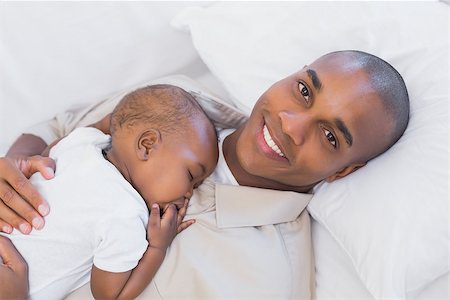 simsearch:614-03576718,k - Happy young father napping with baby son on couch at home in the living room Photographie de stock - Aubaine LD & Abonnement, Code: 400-07722522