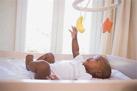 Adorable baby boy lying in his crib playing with mobile at home in the bedroom Stock Photo - Budget Royalty-Free & Subscription, Code: 400-07722548