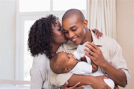 Happy parents feeding their baby boy a bottle at home in the bedroom Stock Photo - Budget Royalty-Free & Subscription, Code: 400-07722567