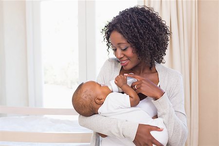 Happy mother feeding her baby boy his bottle at home in the bedroom Stock Photo - Budget Royalty-Free & Subscription, Code: 400-07722561