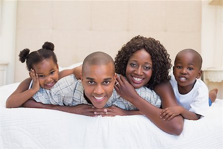 simsearch:642-01735522,k - Happy family smiling at camera together on bed at home in the bedroom Foto de stock - Super Valor sin royalties y Suscripción, Código: 400-07722598