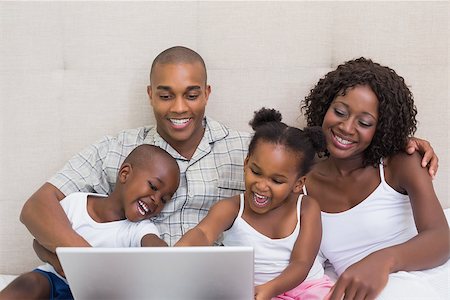 Happy family using laptop together on bed at home in the bedroom Stock Photo - Budget Royalty-Free & Subscription, Code: 400-07722602