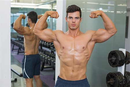 simsearch:400-07723048,k - Portrait of a shirtless muscular man flexing muscles in gym Foto de stock - Royalty-Free Super Valor e Assinatura, Número: 400-07723084