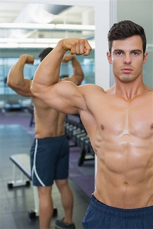 simsearch:400-07723048,k - Portrait of a shirtless muscular man flexing muscles in gym Foto de stock - Royalty-Free Super Valor e Assinatura, Número: 400-07723085