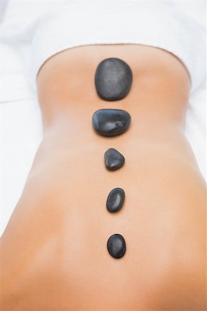 simsearch:400-07723724,k - Close up of a beautiful young woman receiving stone massage at spa center Photographie de stock - Aubaine LD & Abonnement, Code: 400-07723675