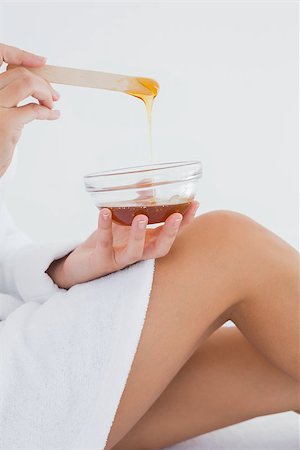 Close up side view of woman holding hot wax in bowl at spa center Stockbilder - Microstock & Abonnement, Bildnummer: 400-07723711