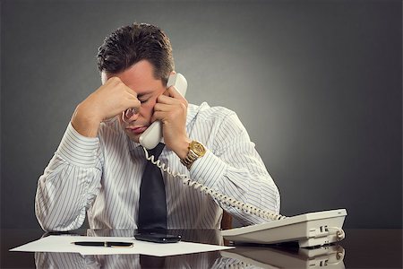 simsearch:400-04591983,k - Overwhelmed businessman in white shirt and tie having a headache during a stressful phone conversation. Tired thoughtful businessman with one hand on his forehead taking a tedious phone call. Fotografie stock - Microstock e Abbonamento, Codice: 400-07745218